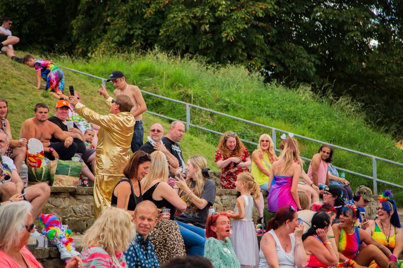 A lively crowd at a celebration, featuring diverse attendees in vibrant outfits.