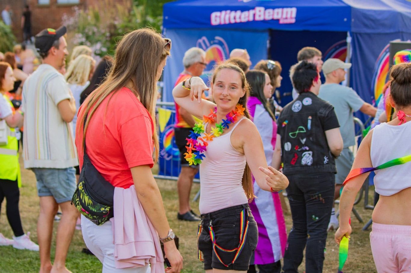 Festival-goers in colourful outfits enjoy a vibrant outdoor event.