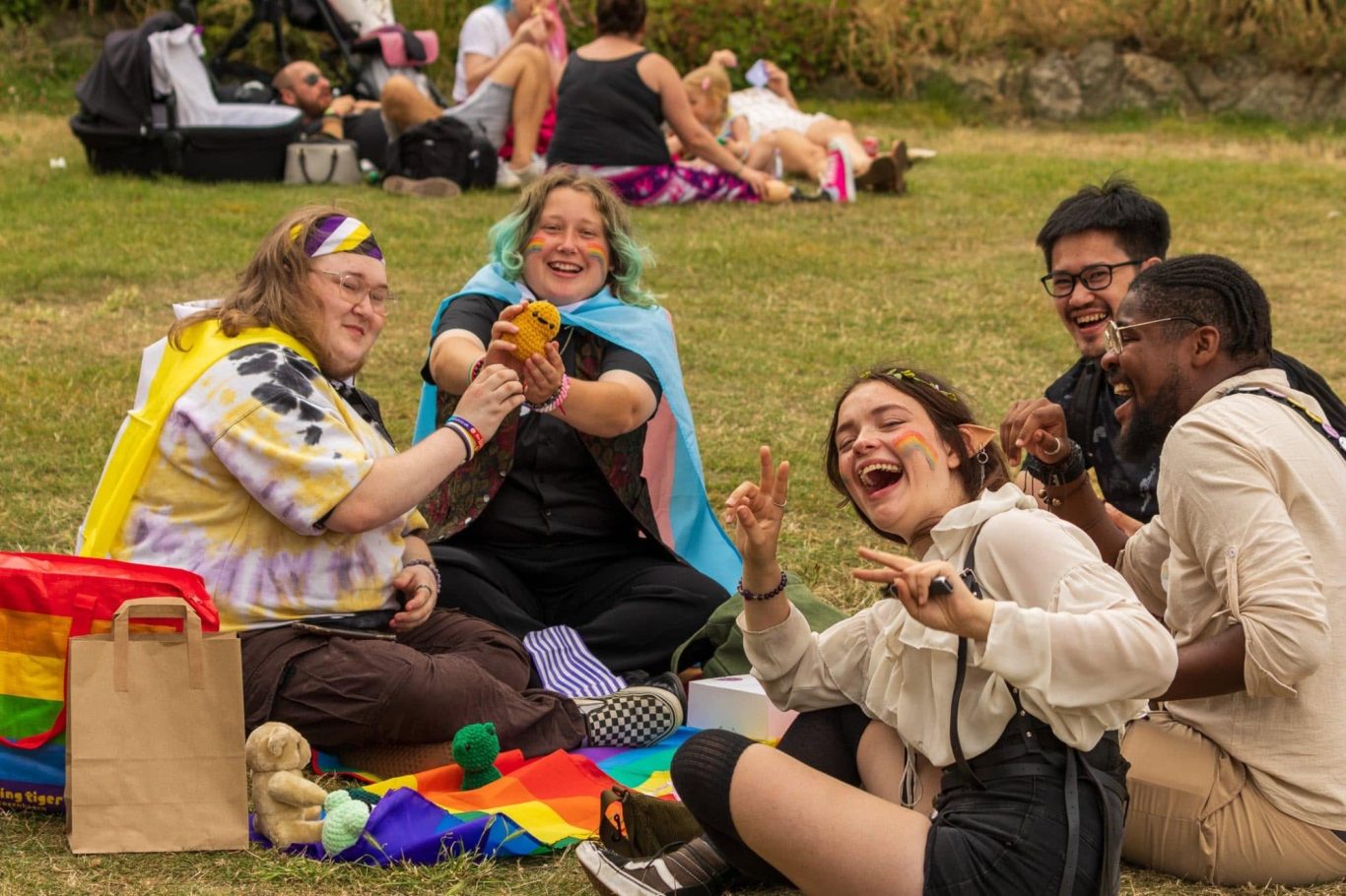 Group of friends enjoying a picnic, dressed in vibrant attire, celebrating together.