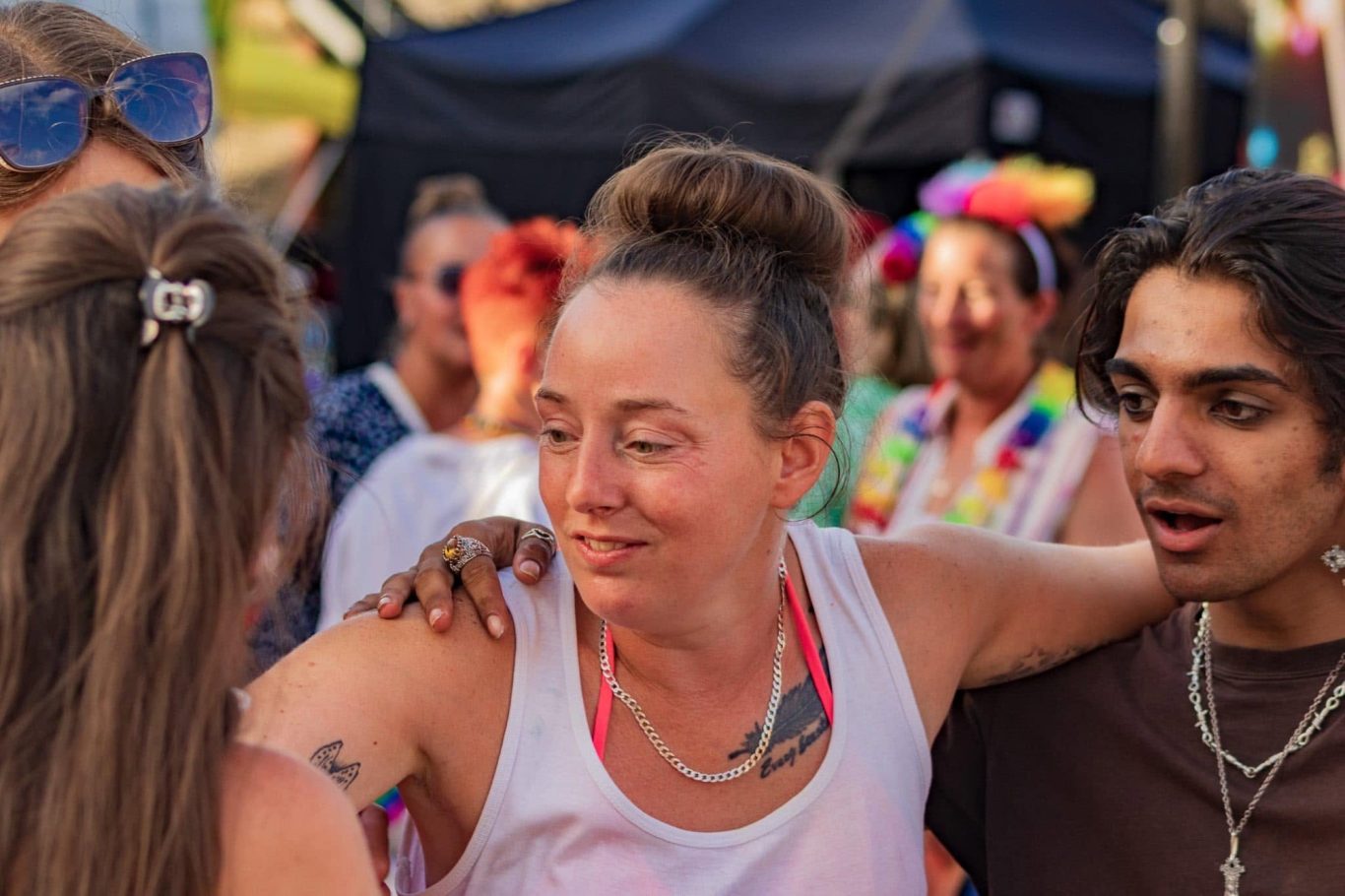 A group of people socialising at a vibrant festival, sharing smiles and laughter.