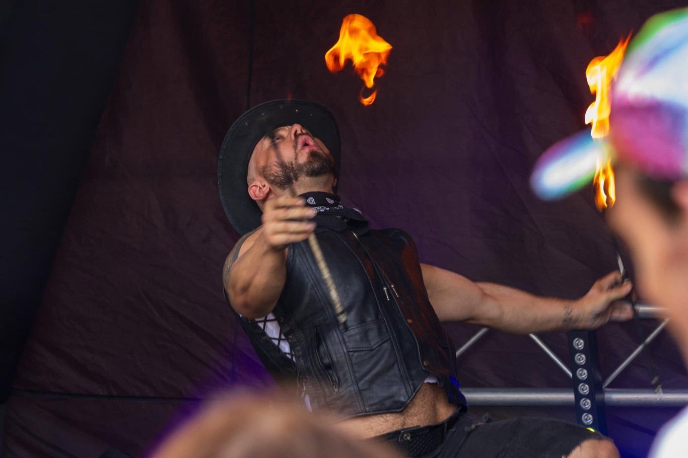 Marshall Arkley - 2024 Fire performer in a black outfit, creating flames while engaging the audience.