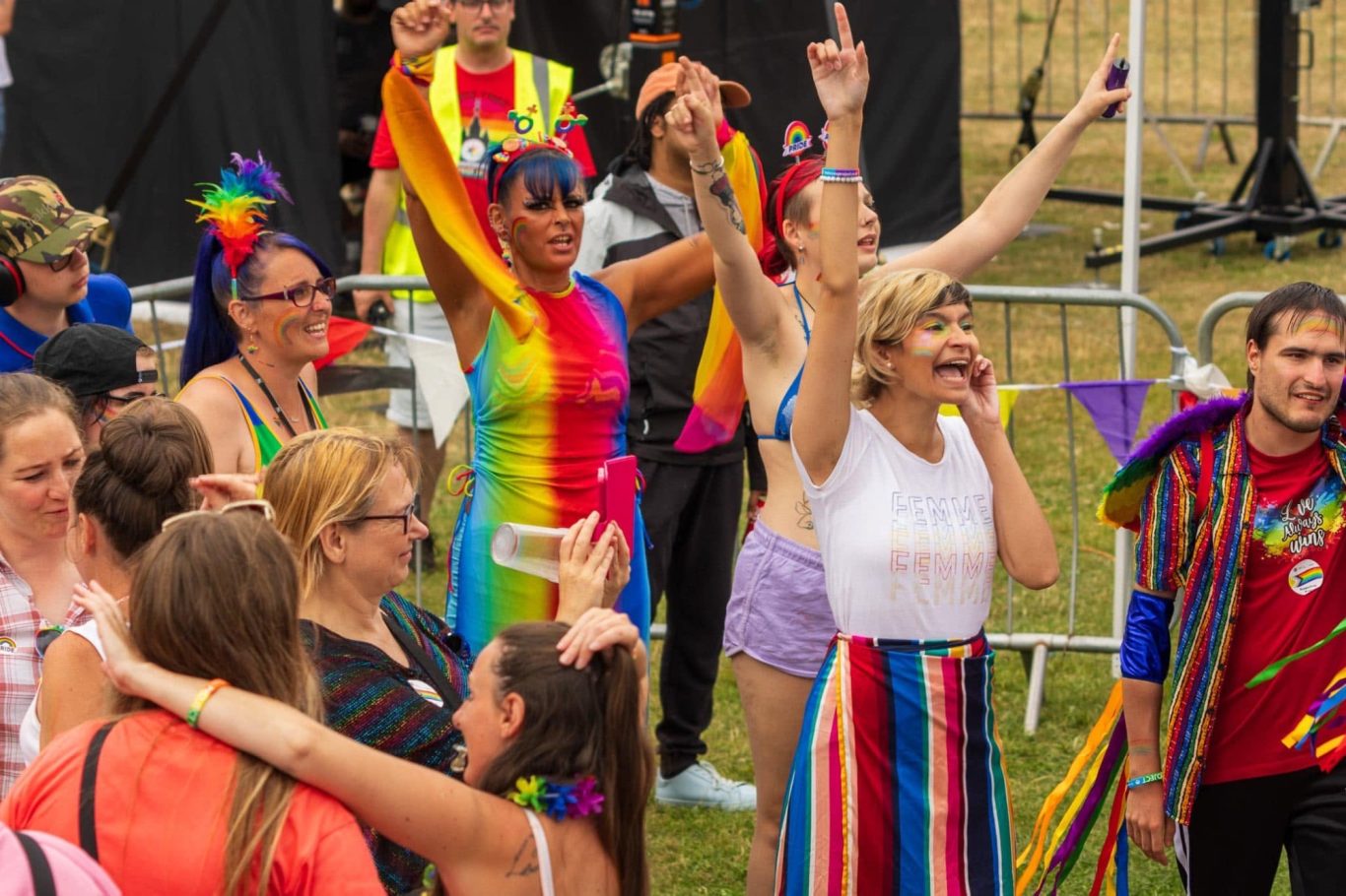 A vibrant crowd celebrating at a festival, wearing colourful outfits and expressing joy.