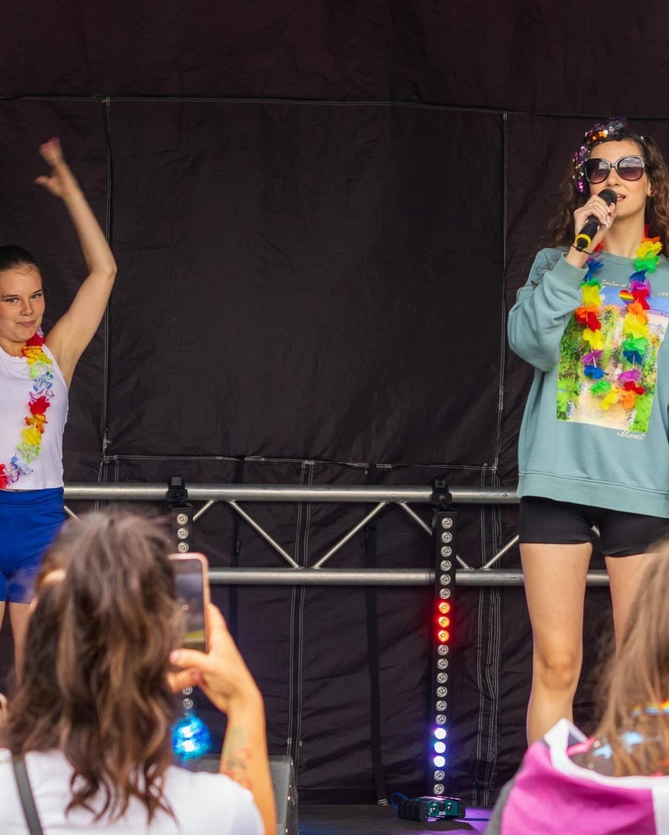GYG - 2024 Two performers on stage in colourful outfits, one singing into a microphone.