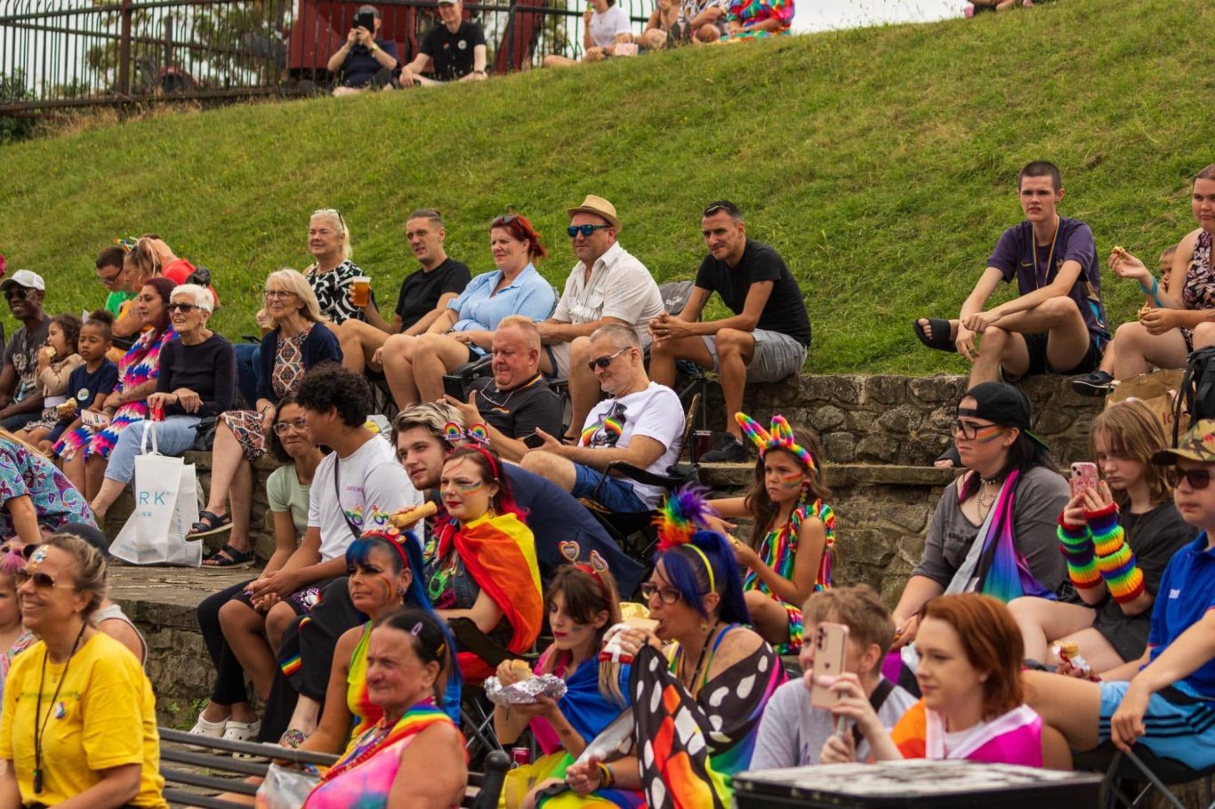 Crowd of people at a celebratory event, wearing colourful attire and enjoying the festivities.