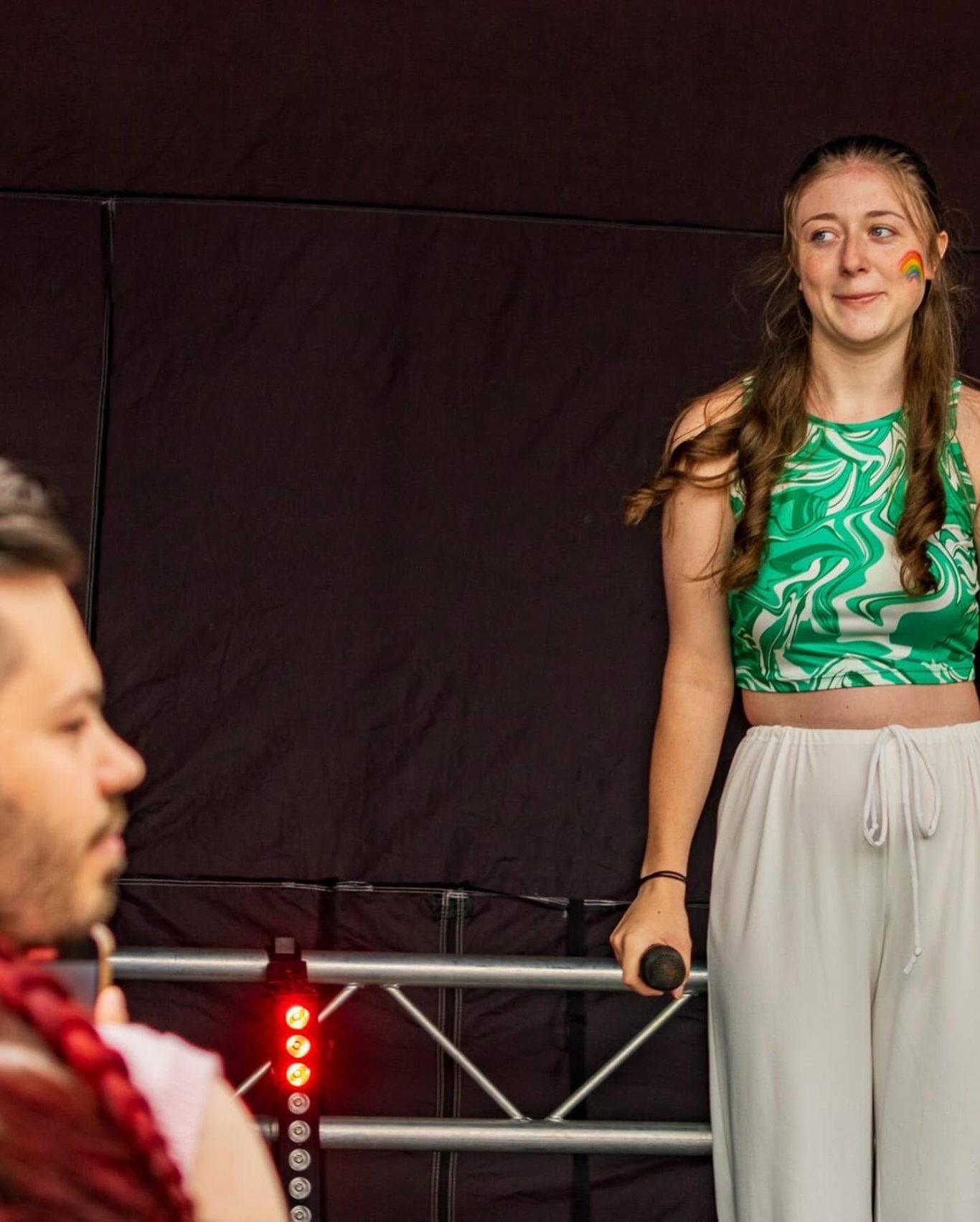 GYG - 2024 A performer in a green crop top sings on stage, engaging with the audience.
