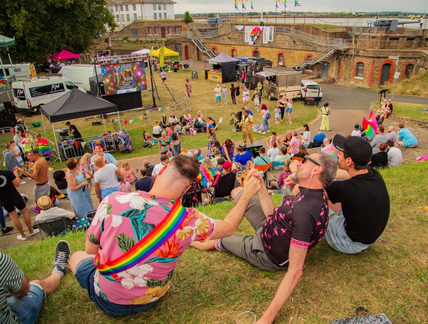 A vibrant outdoor festival scene with attendees enjoying colourful decorations and music.