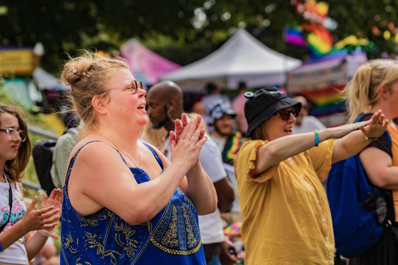 Crowd at a festival, with individuals clapping and enjoying the vibrant atmosphere.