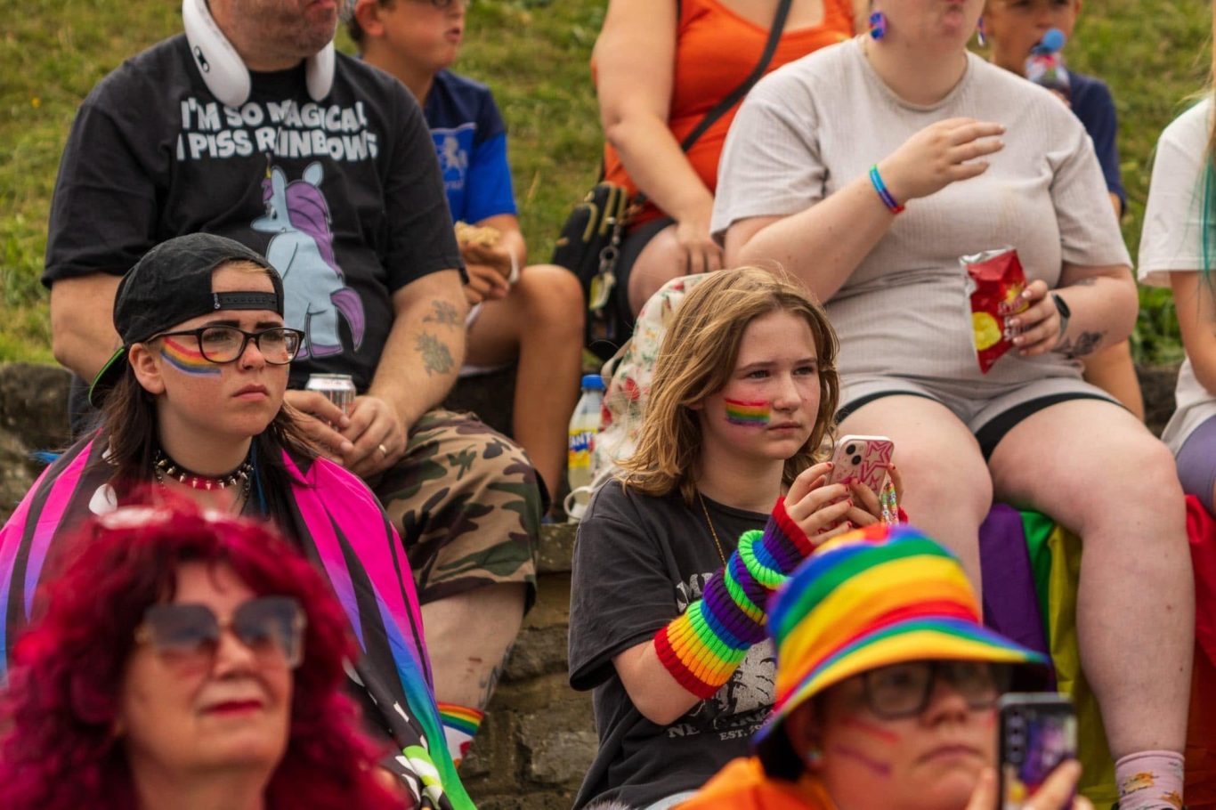 A diverse crowd at a pride event, wearing colourful attire and celebrating inclusivity.