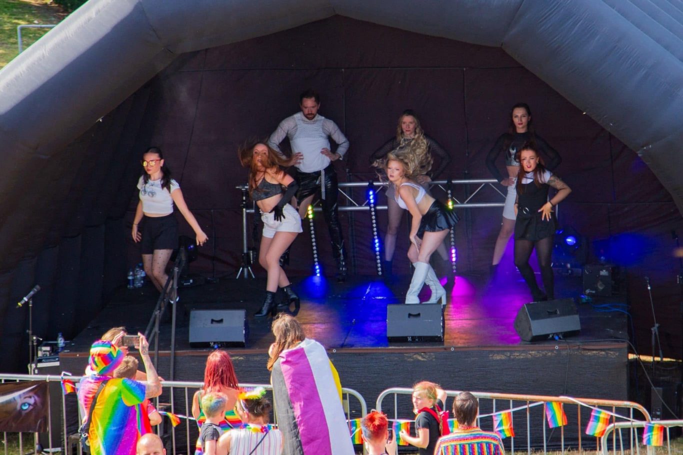 Haus of Heels - 2024 A lively performance on stage with dancers in vibrant outfits at a celebration.